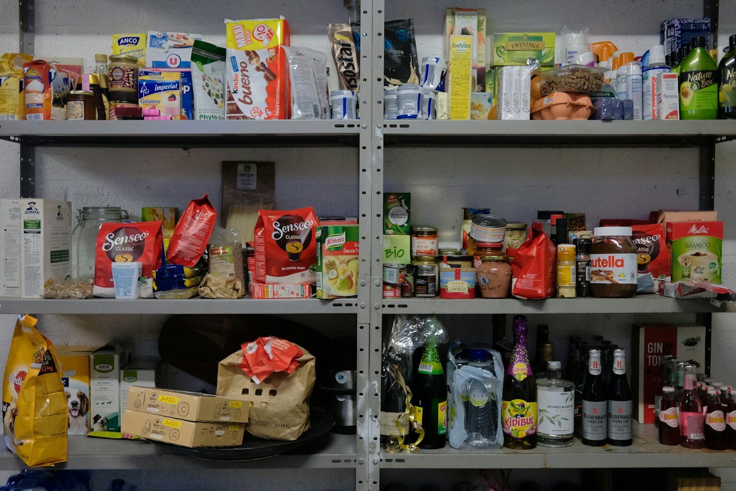 Grey shelves packed with groceries and household supplies.