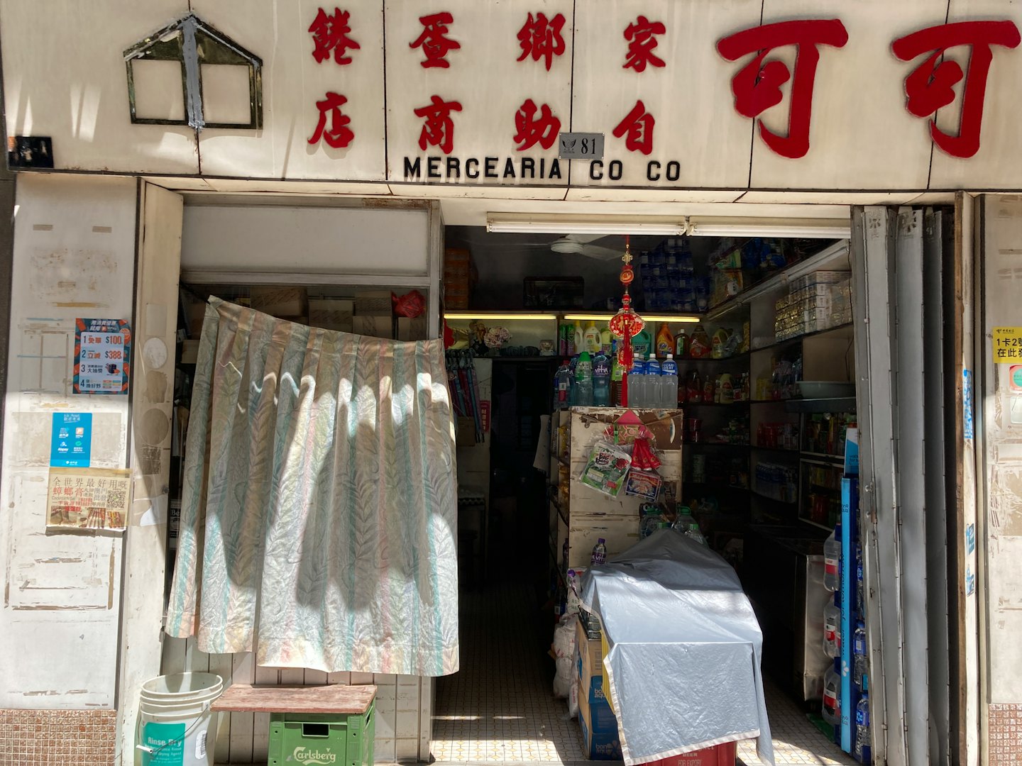 Corner grocery store entrance with a floral curtain in the doorway.