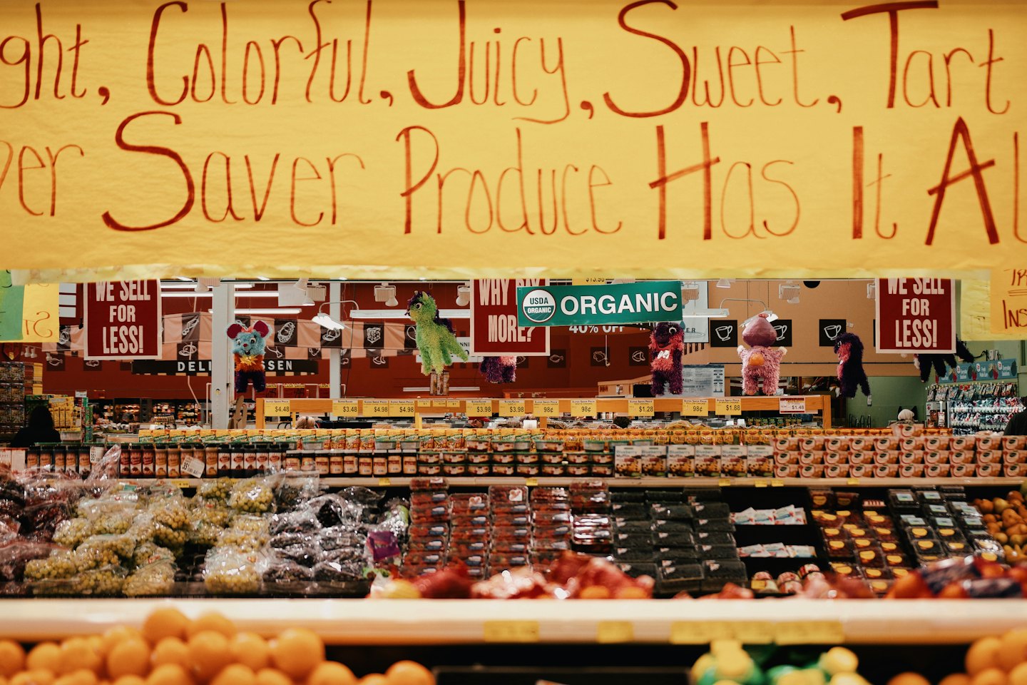 Supermarket produce aisle with colorful fruits and organized shelves.