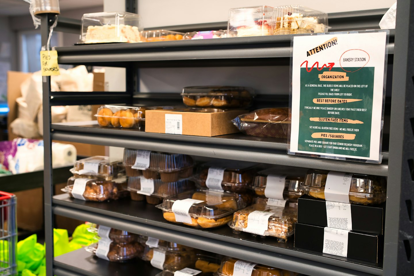 Black metal shelves holding packaged bakery items and a BAKERY STATION sign.